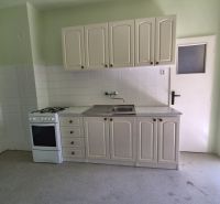 A kitchen in a 3-room apartment with a gas stove and white cabinets.