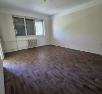A room in a 3-room apartment with a wooden decor floor and a large window.