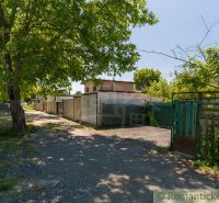 The driveway to the cottage in Bernolákovo surrounded by greenery and shady trees.