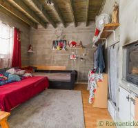 A room in a cottage with a sofa, a tiled stove, and a wooden decor floor, cozy atmosphere.