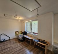 A room with a wooden floor and a table in a studio apartment.
