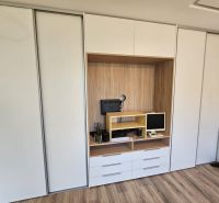 Built-in wardrobe with a work nook, floor with wooden decor in a studio apartment.