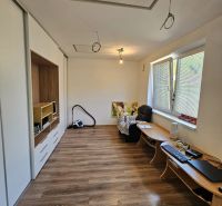 Interior of a 1-room apartment with a wooden decor floor and minimalist furniture.