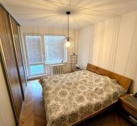 Bedroom in a 3-room apartment with a wood-patterned floor and practical lighting.