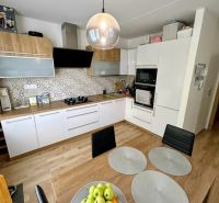 A kitchen in a 3-room apartment with white cabinets and a wood-patterned floor.