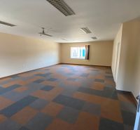 Commercial space with a geometric floor and a window, ideal for rent or an office.