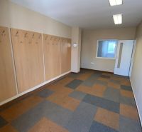 Commercial space with patterned flooring, wall hooks, and white doors.