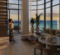 Spacious interior of a 1-bedroom apartment with large windows and a view of the sunset.