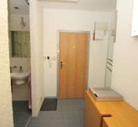 A hallway in a 3-room apartment with tiles and a mirror.