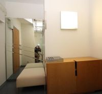 A hallway in a 3-room apartment with a mirror, a bench, and a wooden cabinet.