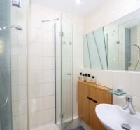 A bathroom in a 3-room apartment with a shower corner and a mirrored wall.