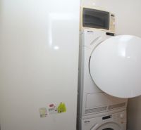 Washing machine and dryer in the bathroom of a 3-room apartment with a microwave.
