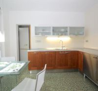 A kitchen in a 3-room apartment with a dining table and white chairs.