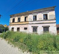 A family house in Klátova Nová Ves with a cracked facade and an overgrown garden.