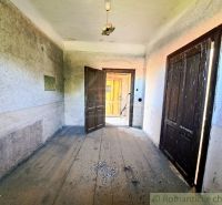 A hallway in a family house with a wooden floor and open doors.
