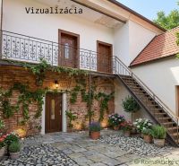 A family house in Klátova Nová Ves with a brick wall, wooden door, and staircase.
