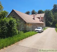 A family house in Klátova Nová Ves with a brick roof by the road and a parked car.