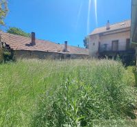Overgrown yard between the buildings of a family house in Klátova Nová Ves.
