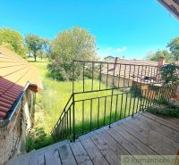 The view from the family house in Klátova Nová Ves to the garden with grass and trees.