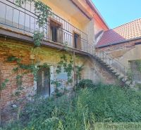 A family house in Klátova Nová Ves with a brick facade, covered in greenery, and a staircase.