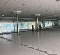 Spacious commercial spaces with tiles and mirrors, suitable for various uses.