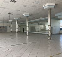Commercial premises with tiles and columns, suitable for various activities.