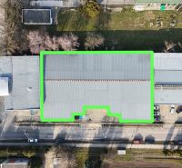 Commercial premises on 1. mája Street in Hurbanovo with a distinctive roof and adjacent greenery.