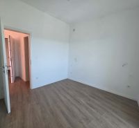 A room with white walls and a wooden decor floor in a 2-room apartment.