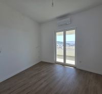 A room in a two-room apartment with a wooden decor floor and a balcony.