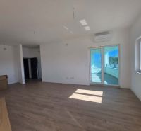 Living room of a two-room apartment with a wooden decor floor and balcony doors.
