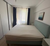 Bedroom in a 3-room apartment with a bed, blue curtains, and a built-in wardrobe.