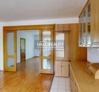 A kitchen unit in a 3-room apartment with sliding doors and a wooden decor floor.