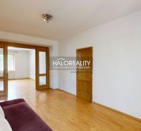Living room in a 3-room apartment with a wooden decor floor and a comfortable couch.