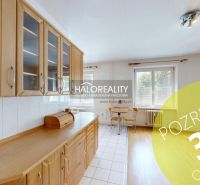 A kitchen in a 3-room apartment with wooden decor cabinets and a dining table.