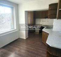 A kitchen in a 3-room apartment with a kitchen unit and a floor with a wooden decor.