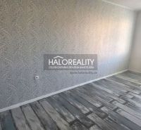 A room in a 3-room apartment with decorative wallpaper and a wooden decor floor.