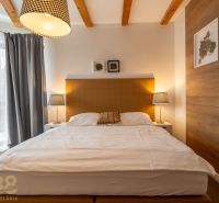 Bedroom with a double bed, lamps, and decoration in a 3-room apartment, floor with wooden decor.