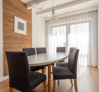 Dining table with dark chairs, bright interior, and floor with wood decor.
