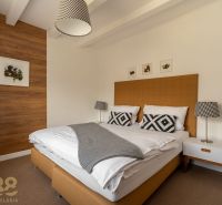 Bedroom in a 3-room apartment, with a bed and a wall with wooden decor.