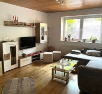Living room in a family house with a sofa, cabinets, and a wooden decor floor.