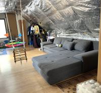 An attic room in a family house with a hanging swing, a wooden decor floor, and toys.