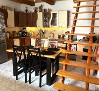 A kitchen in a family house with wooden decor and stairs.