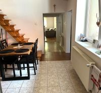 A kitchen in a family house with a dining table and a staircase.
