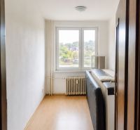 A room in a 3-room apartment with a wooden decor floor and a large window.