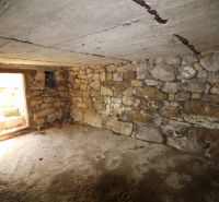 A stone cellar space in the construction phase of houses, showing raw walls and ceiling.