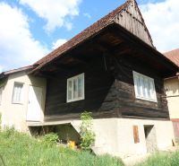 A log cabin with a concrete foundation on Matúšovská Street, Žaškov, surrounded by green grass. Construction of houses.