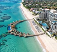 Beach resort by the turquoise sea with white sand and wooden villas in Paje.
