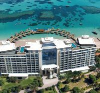 A hotel in Paje with a view of the turquoise sea and boats on the beach.