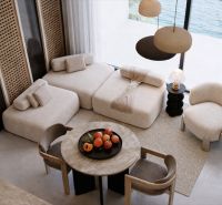 Living space with comfortable sofas, a round table, and a view of the sea.