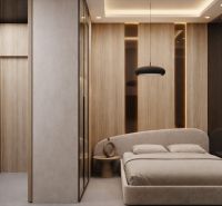 A bedroom in a studio apartment with a wood-patterned floor and minimalist furnishings.